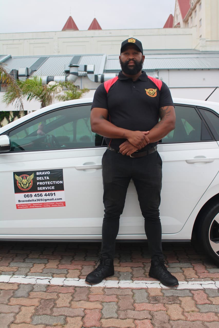 Bravo Delta professional security guard standing beside a response vehicle